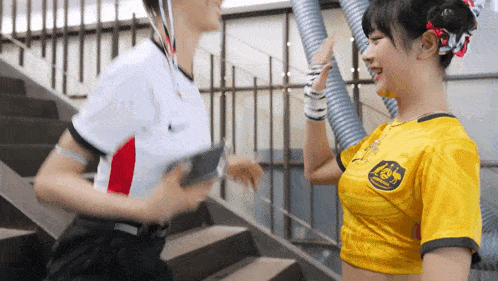 a man and a woman are standing on a set of stairs and the woman is wearing a yellow shirt with australia on it