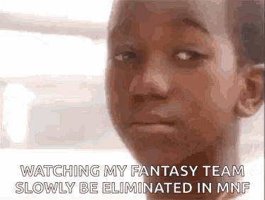 a young boy is making a funny face while watching a fantasy team slowly be eliminated in mnf .