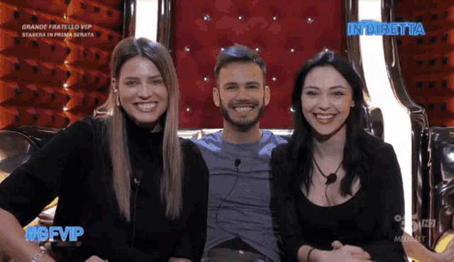 a man and two women are smiling in front of a sign that says in diretta on it