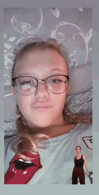 a girl wearing glasses and a shirt with rolling stones on it