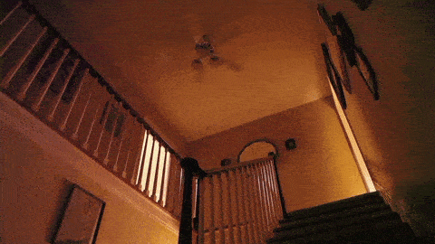 a staircase with a ceiling fan hanging from it