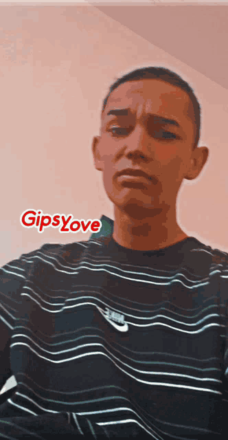 a young man wearing a black and white striped shirt with the word gipsylove on the bottom right
