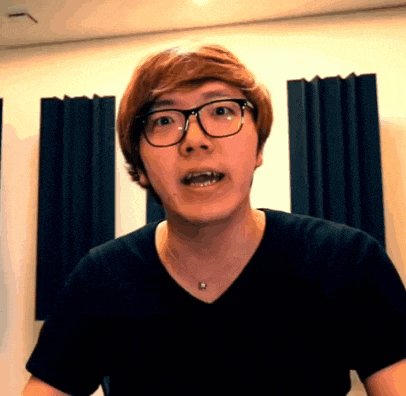 a man wearing glasses and a black shirt looks surprised