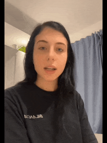 a woman wearing a black t-shirt that says acmajnb on it