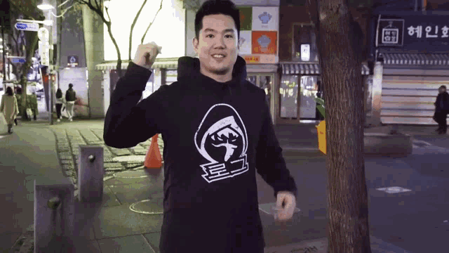 a man wearing a black hoodie with a white graphic on it