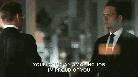 two men in suits are hugging each other and the words `` your doing an amazing job im proud of you '' are visible .