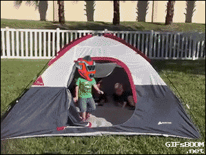 a boy in a red helmet stands in a tent