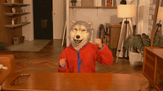 a person wearing a wolf mask is sitting at a table in a living room