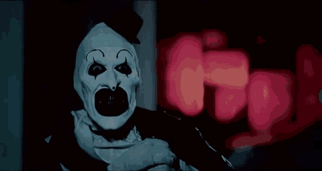 a scary clown is standing in a dark room