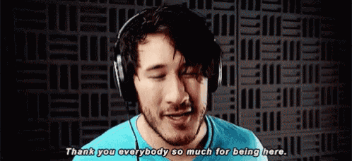 a man wearing headphones is talking and saying `` thank you everybody so much for being here . ''