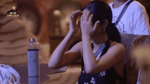 a woman covering her face in front of a new episode
