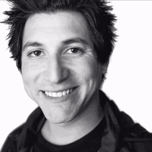a black and white photo of a smiling young man