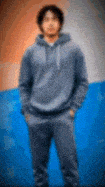 a blurry picture of a man wearing a hoodie and sweatpants