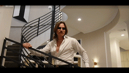 a man in a white shirt is standing on a set of stairs .