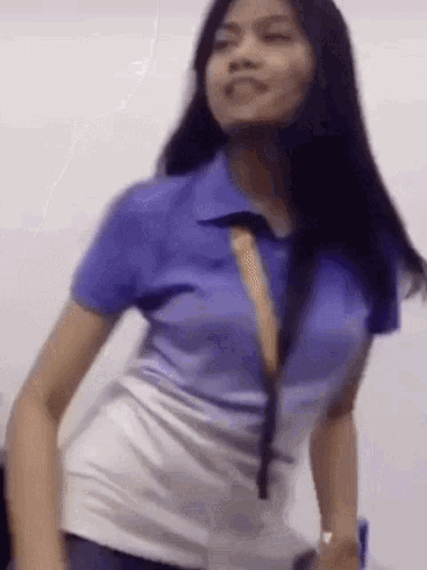a woman wearing a blue shirt and a white skirt is dancing .