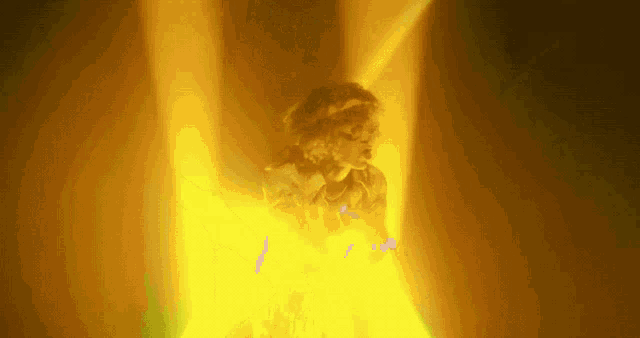 a person is standing in a dark room with a yellow light behind them