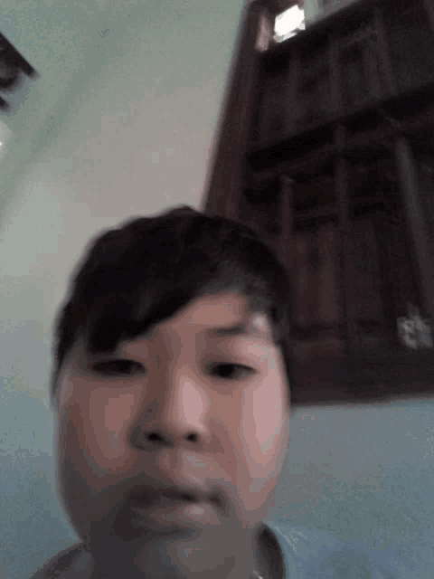 a young boy is taking a selfie in front of a wooden door