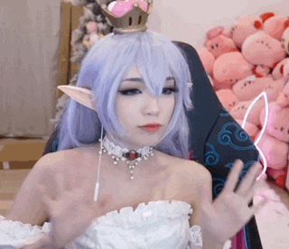 a woman is wearing a purple wig and a crown on her head .