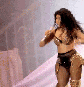 a woman is dancing on a stage while holding a microphone in her hand .