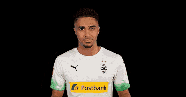 a man wearing sunglasses and a postbank jersey