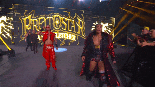 two wrestlers are walking in front of a protestan sign