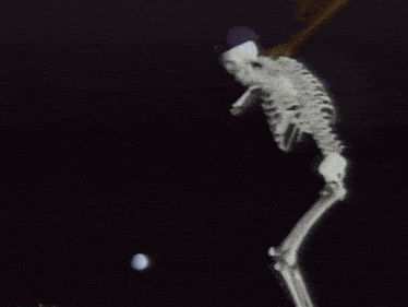 a skeleton is standing next to an egg with a baseball bat