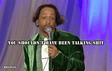 a man in a green jacket holds a microphone and says you should n't have been talking shit