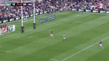 a rugby game is being played in front of a large crowd and the score is 13 to 35