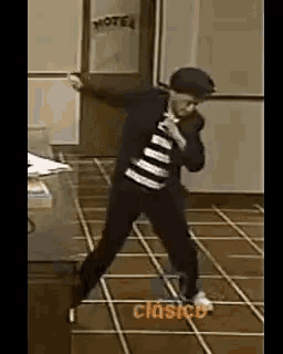 a man in a striped shirt is dancing in front of a door that says motel on it