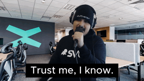 a man singing into a microphone with the words " trust me i know " below him