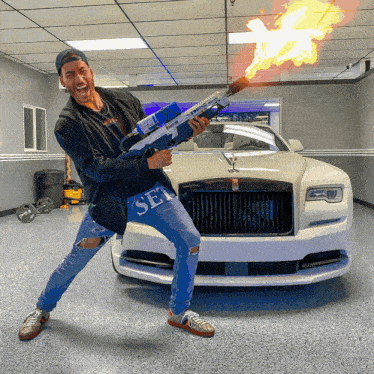 a man holding a gun in front of a car with the word sex on his jeans