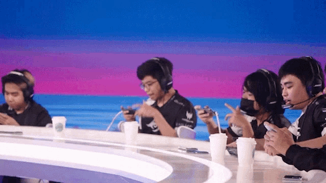 a group of people are sitting at a table playing a game