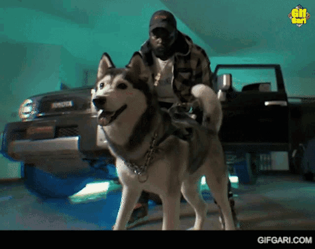 a man is standing next to a dog in front of a toyota truck