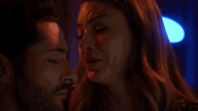 a man and a woman are kissing with their eyes closed .