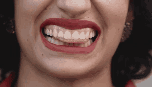 a close up of a woman 's mouth with red lipstick