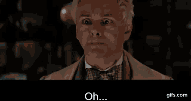 a man with white hair and a bow tie is making a funny face and saying `` oh ... '' .