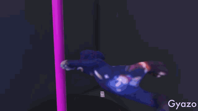 a blue teddy bear is standing in front of a purple object .