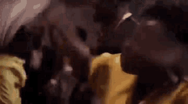 a man in a yellow shirt is dancing in a crowd .