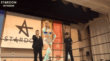 a woman is standing in a wrestling ring in front of a sign that says stardom .