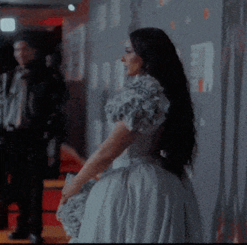 a woman in a dress with flowers on the sleeves
