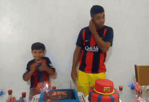 a man wearing a qatar jersey stands next to a boy