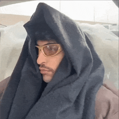 a man wearing sunglasses and a scarf around his neck