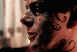 a close up of a man 's face with tattoos on it