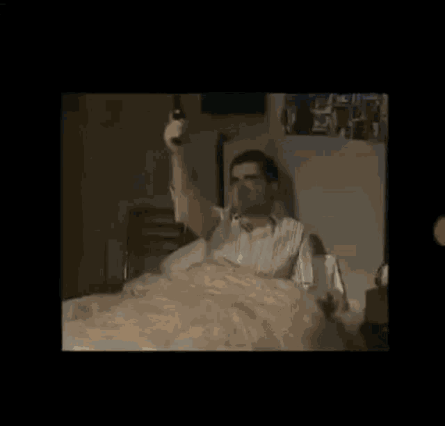 a man is laying in a bed with a lamp hanging from the ceiling .