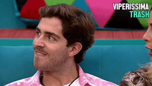 a man in a pink shirt is sitting next to a woman with the words viperissima trash written on the bottom
