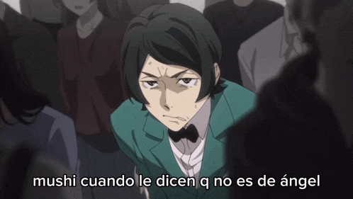 a man in a green suit stands in front of a crowd with the words mushi cuando le dicen q no es de angel above him