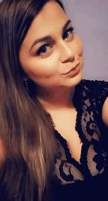 a woman taking a selfie with a black lace top on
