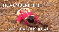 a baby is laying on the ground in the dirt with a caption that says `` november !!! not jealous at all '' .