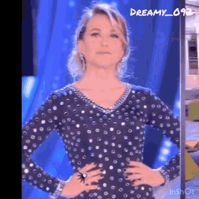 a woman in a polka dot dress is standing with her hands on her hips