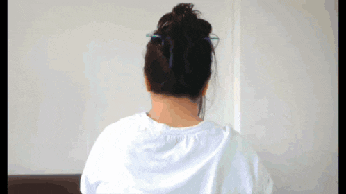a woman with glasses and a bun on her head